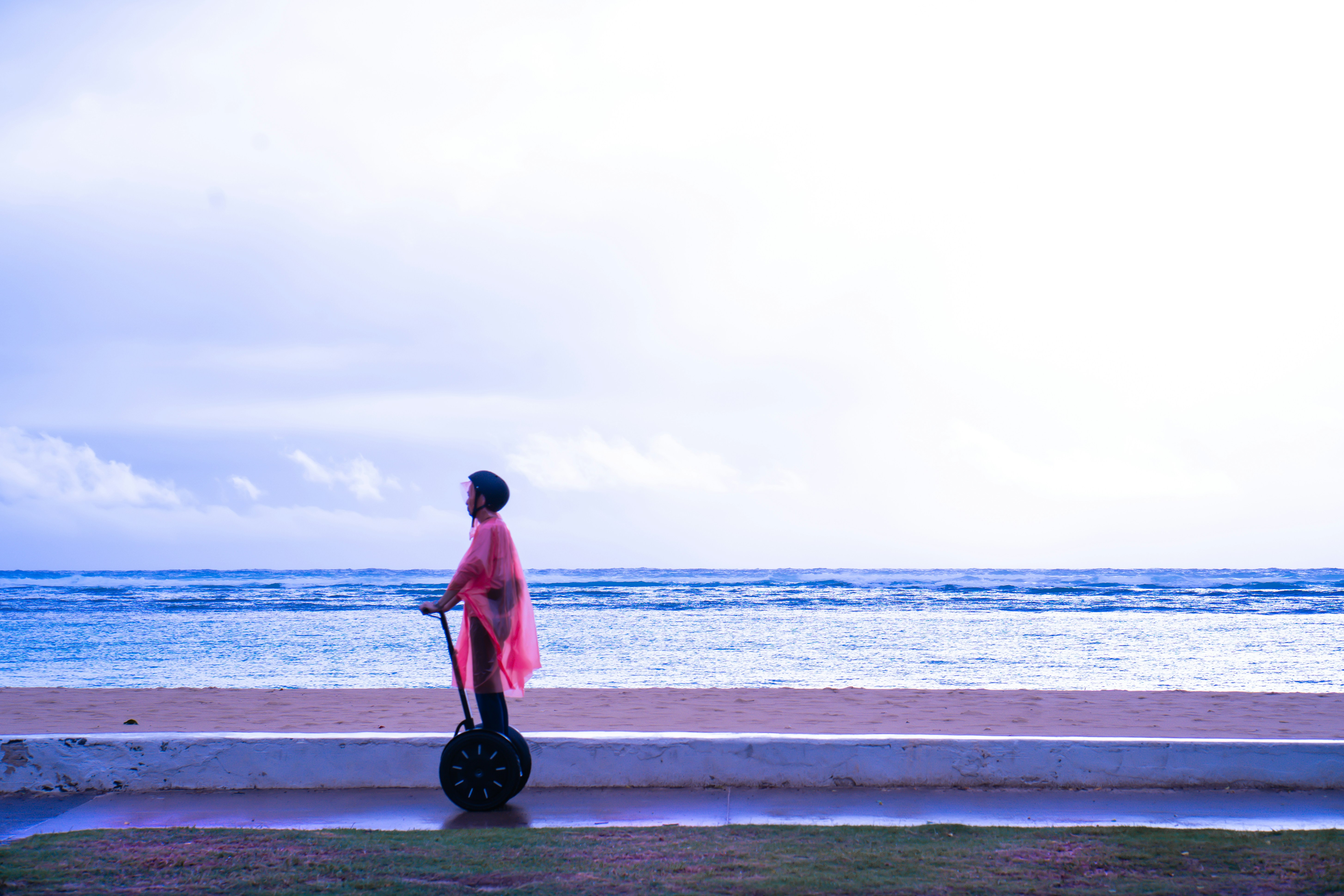 man in red shirt and black pants standing on beach shore during daytime