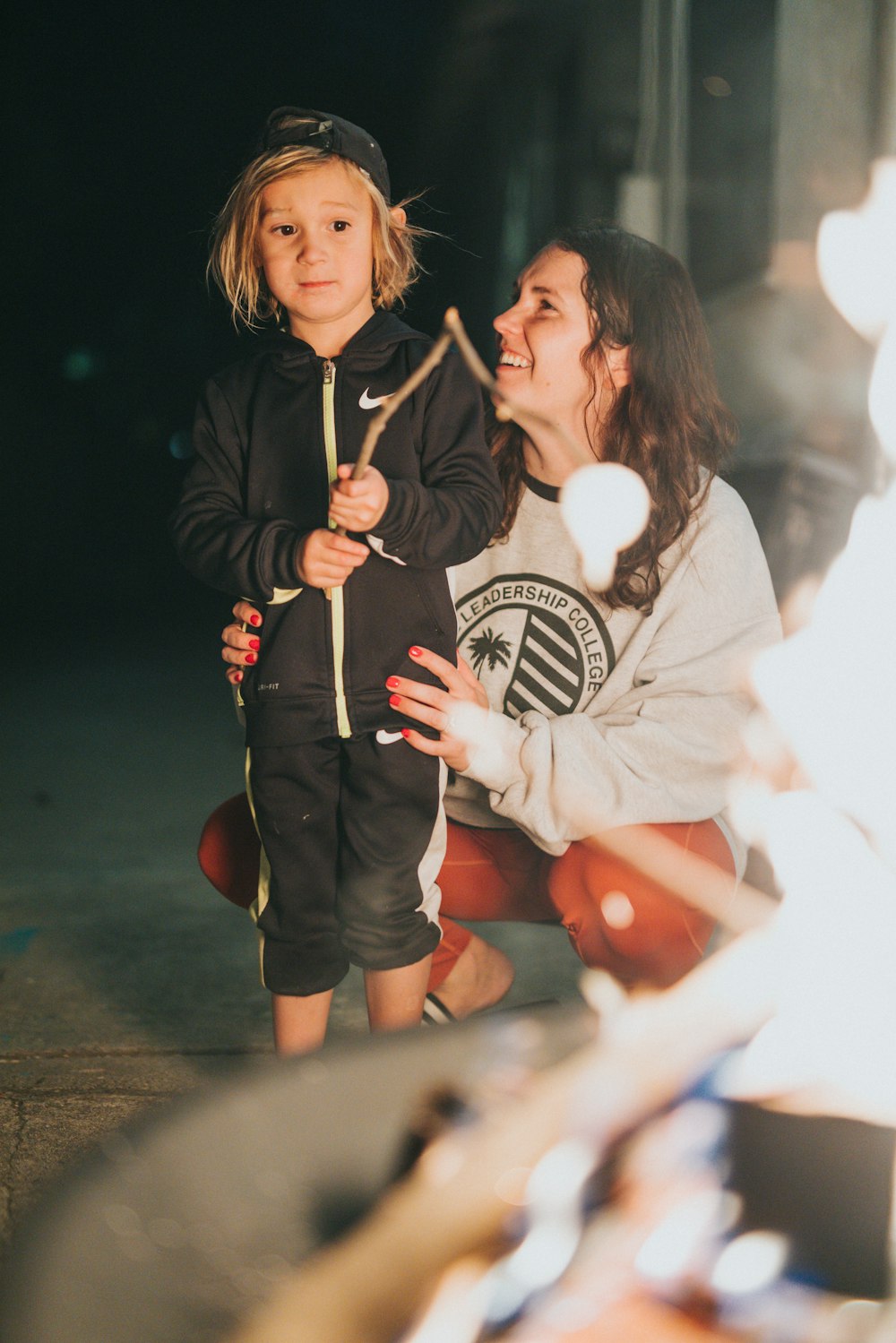 girl in black jacket holding white light bulb