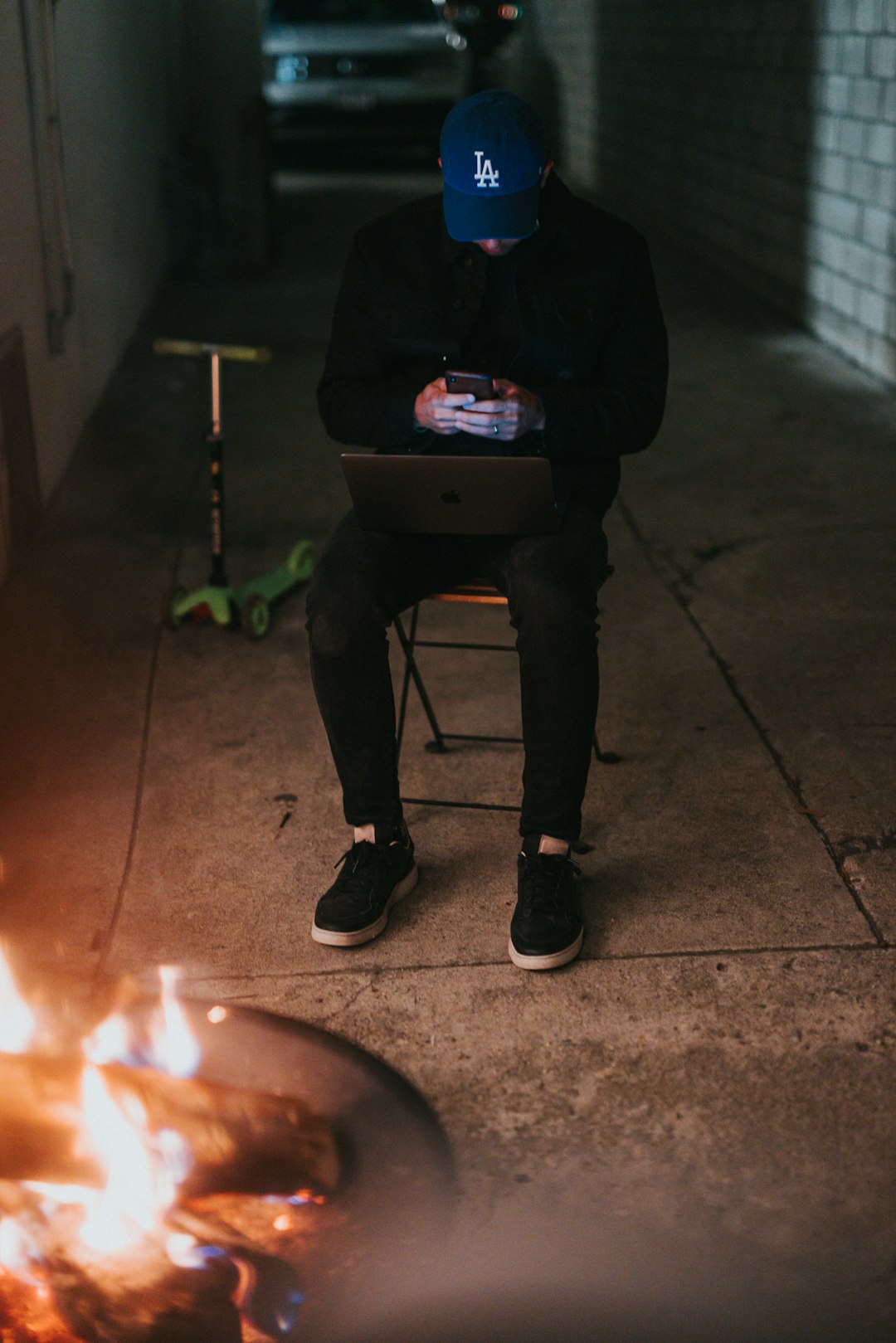 man in black jacket and black pants sitting on chair