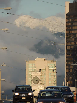 A rental car parked in front of a cityscape with a clock overlay