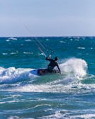man surfing on sea waves during daytime