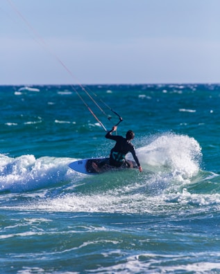 man surfing on sea waves during daytime