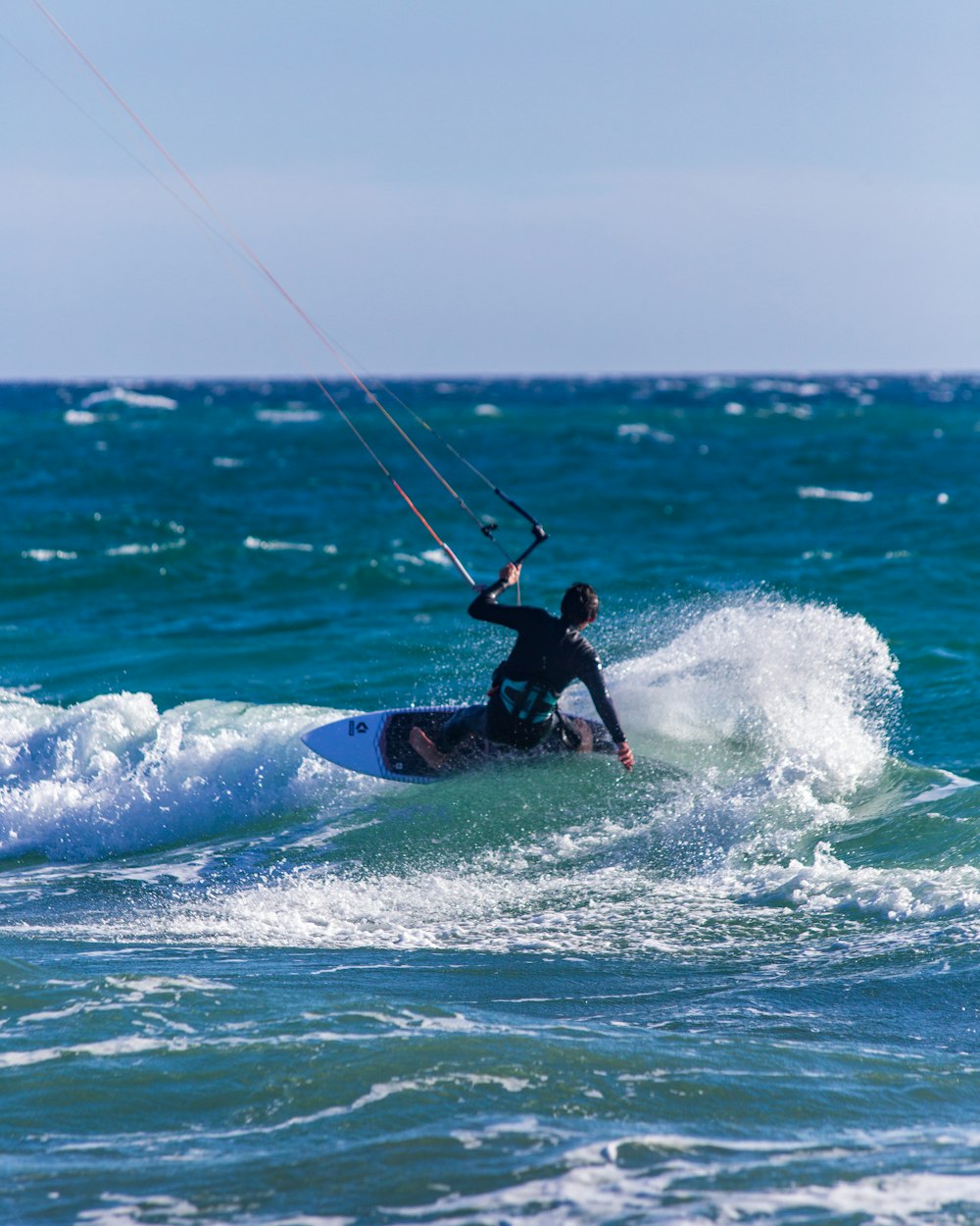 昼間、海の波でサーフィンをする男