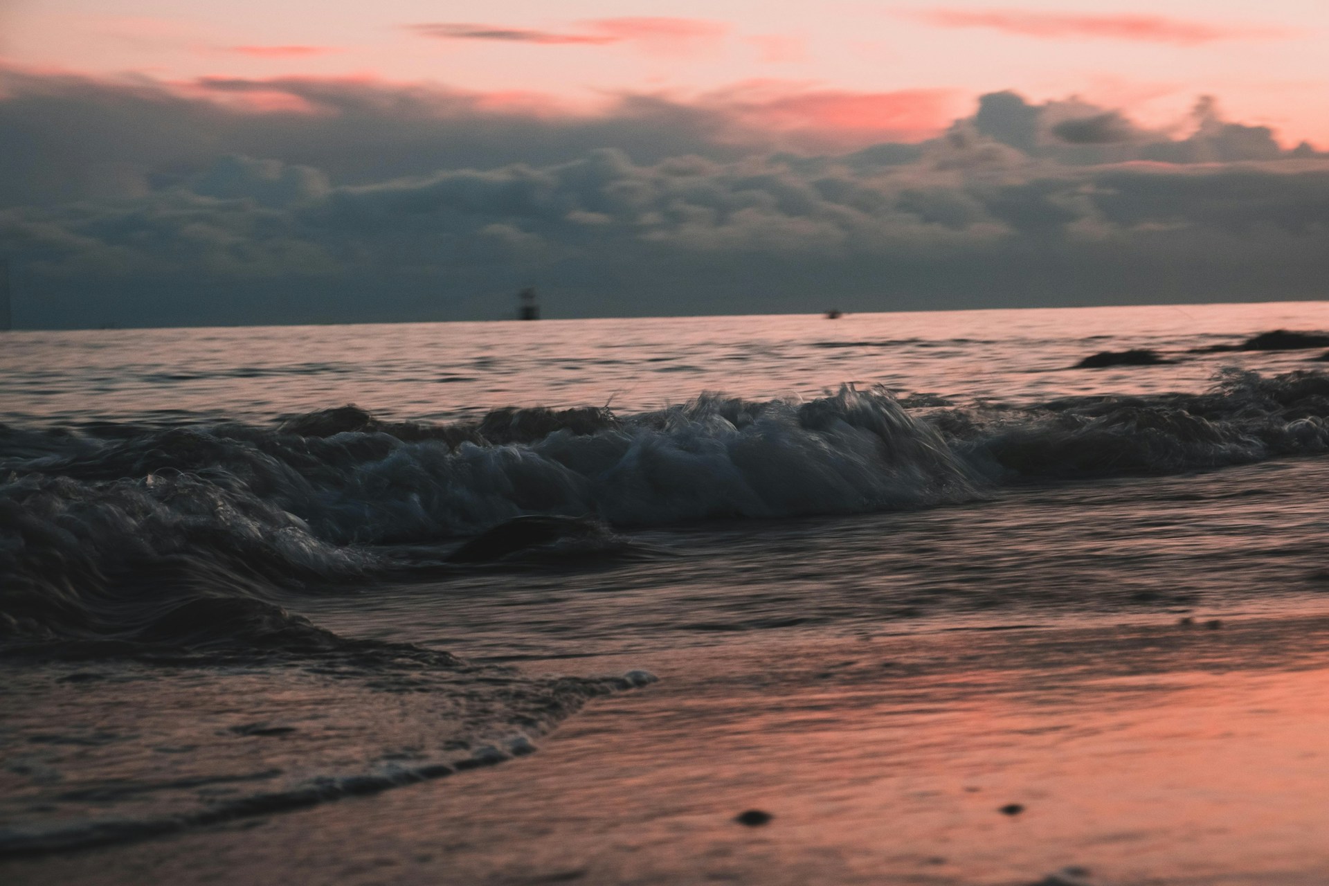 ocean waves crashing on shore during sunset