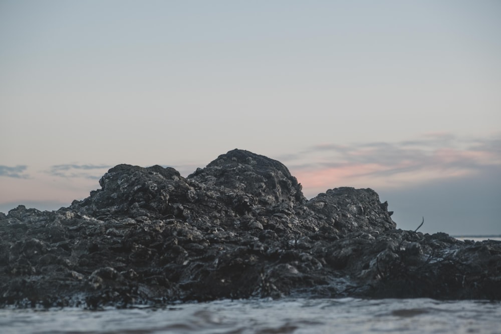 black rock formation on sea during daytime