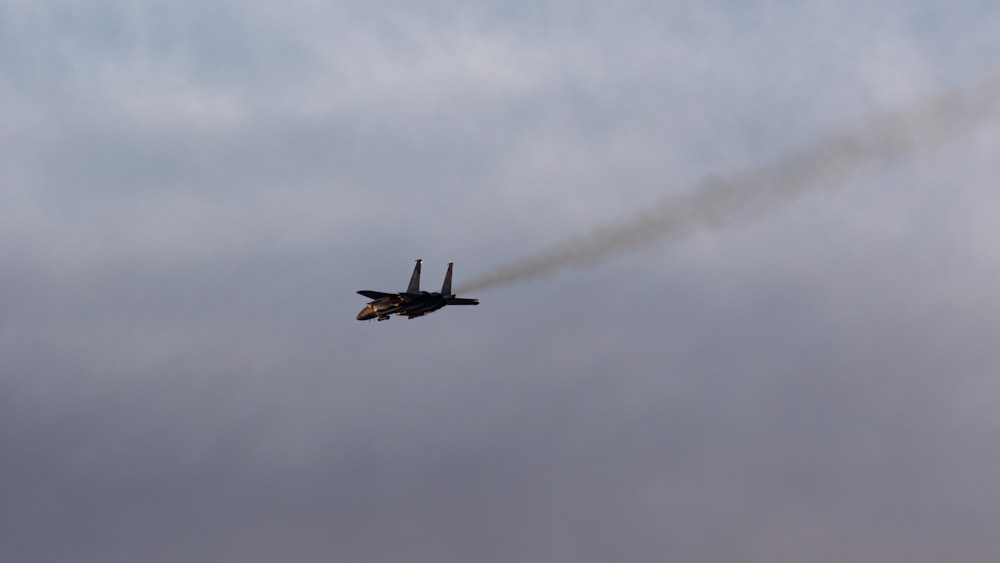 black airplane flying in the sky