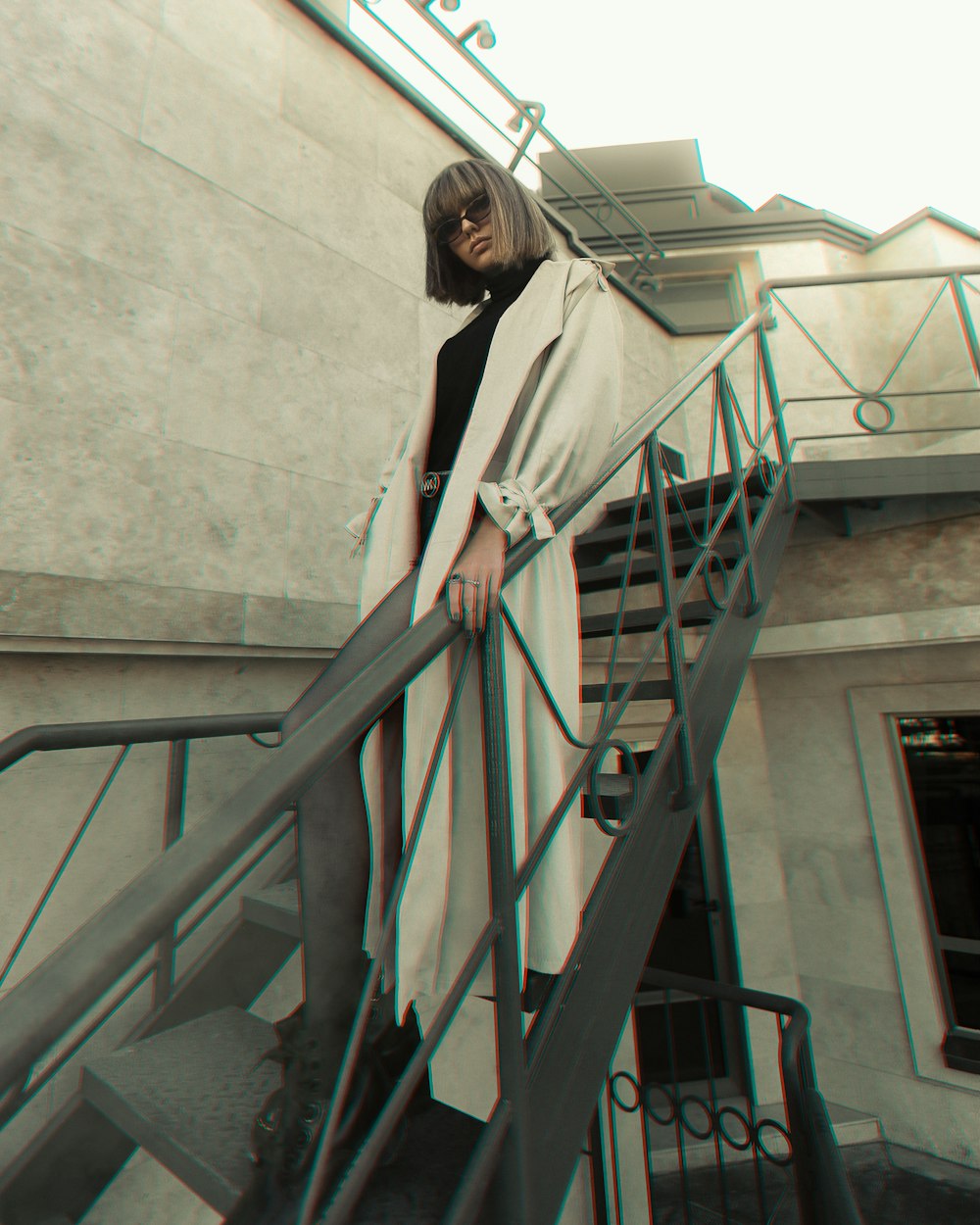 Mujer en camisa blanca de manga larga de pie en las escaleras