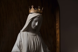 A serene statue of Mary bathed in soft light, surrounded by candles symbolizing devotion