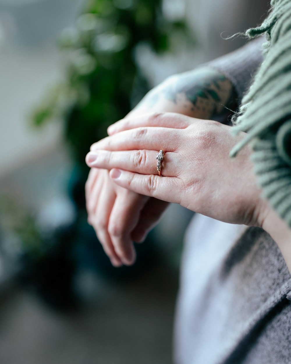 person in gray long sleeve shirt holding silver ring