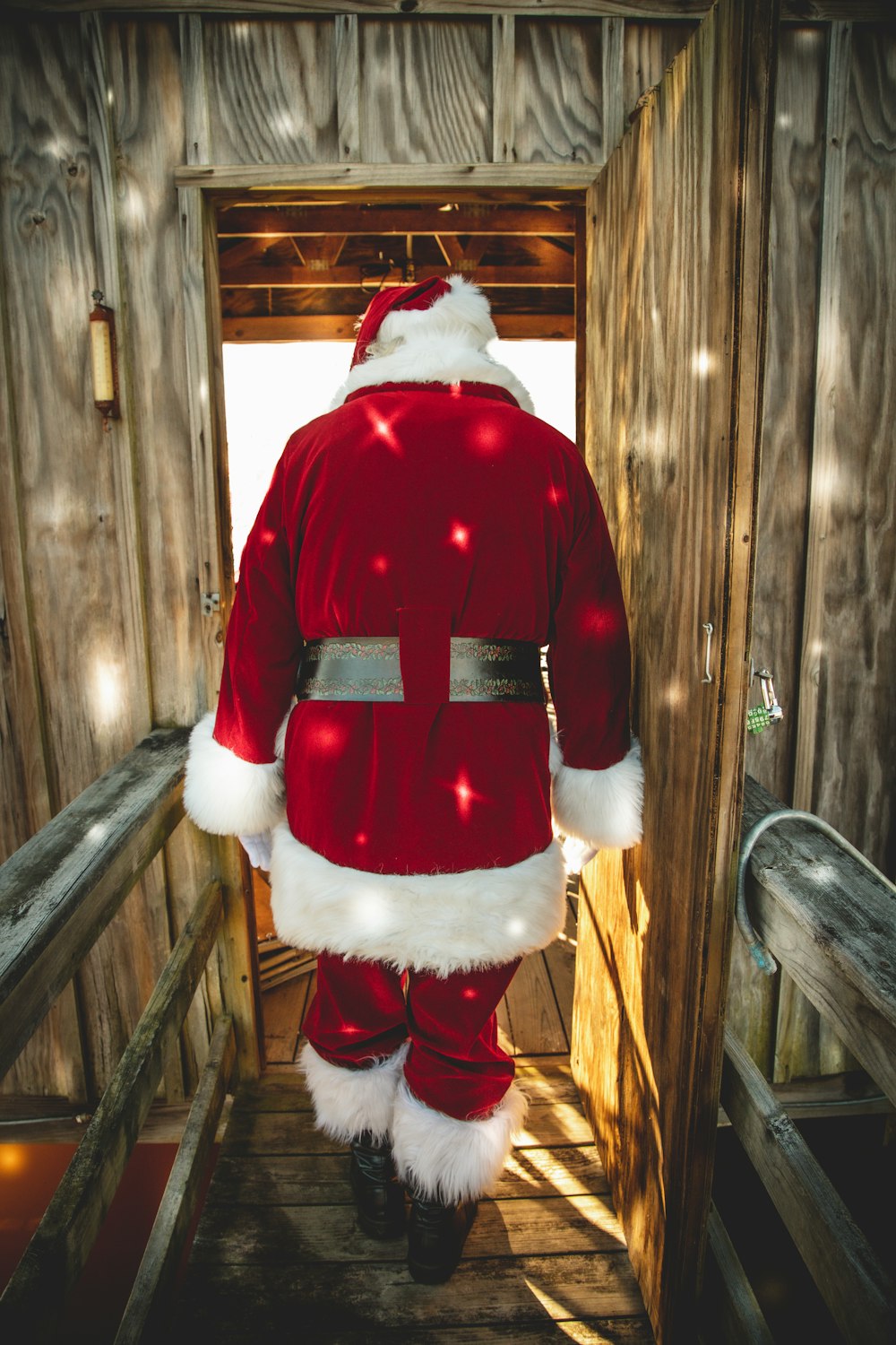 Juguete de peluche de Papá Noel en banco de madera marrón