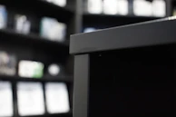 Close-up of sleek electrical appliances displayed on a wooden shelf.