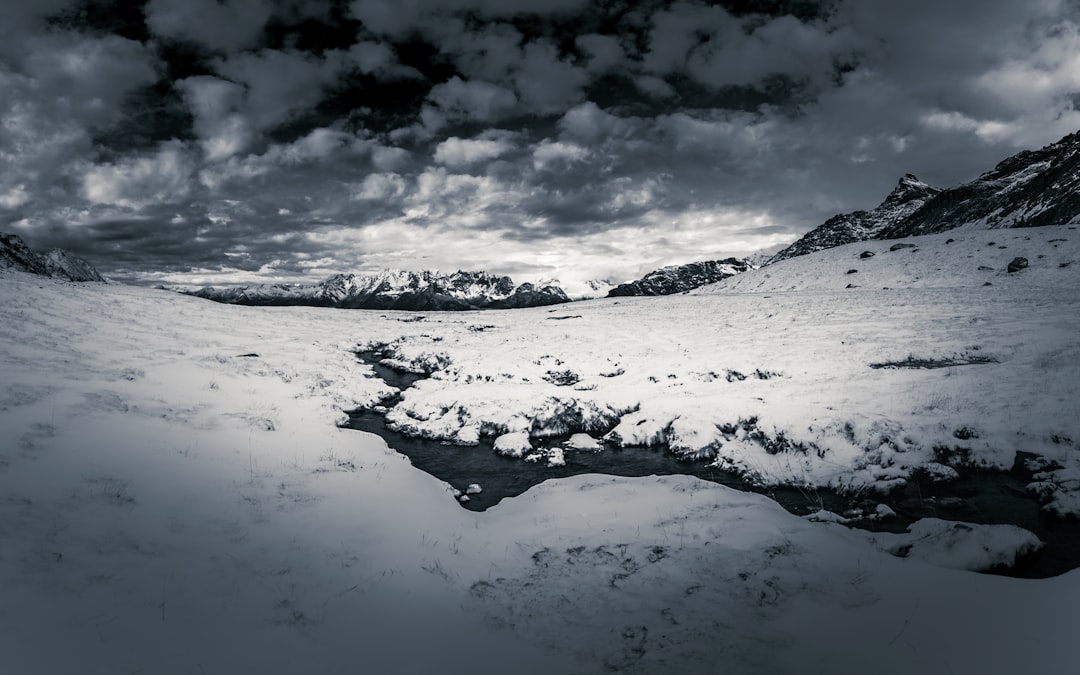 snow covered mountain near body of water