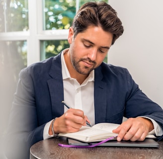 man in blue suit jacket holding white tablet computer