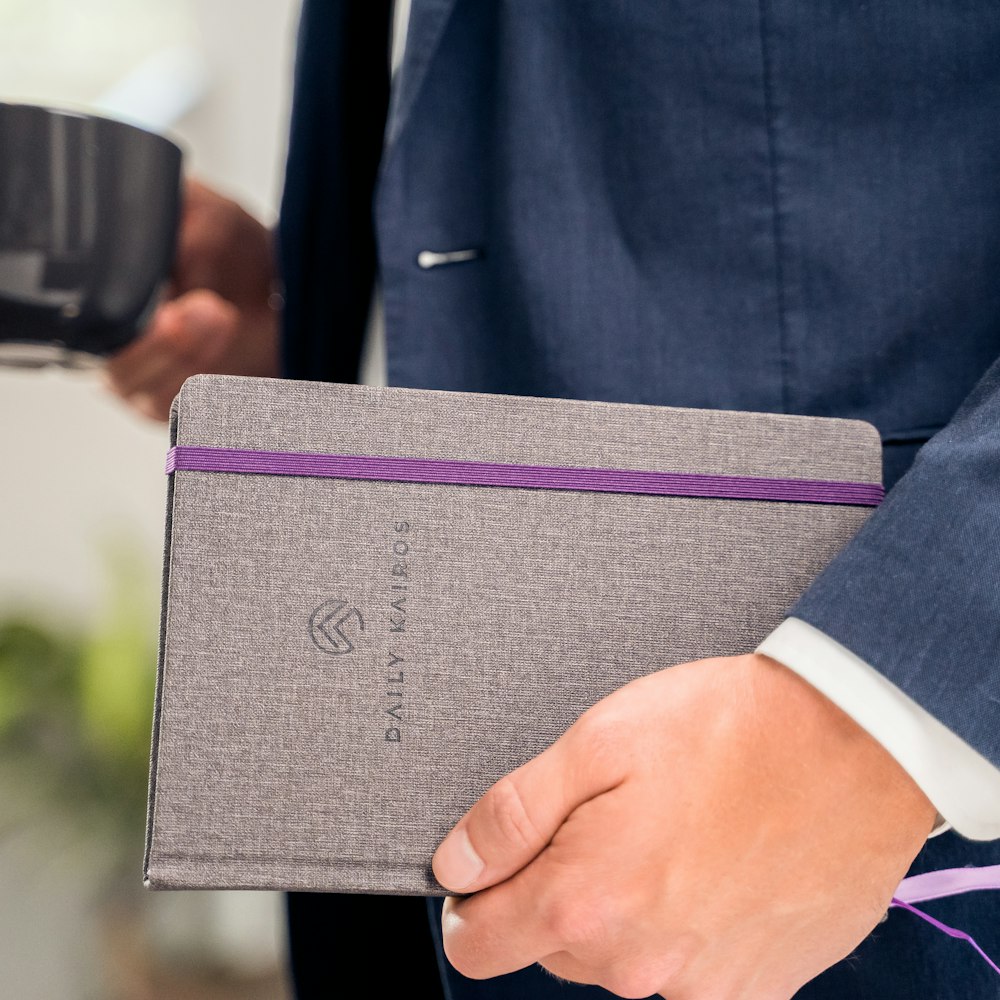 person holding purple book during daytime