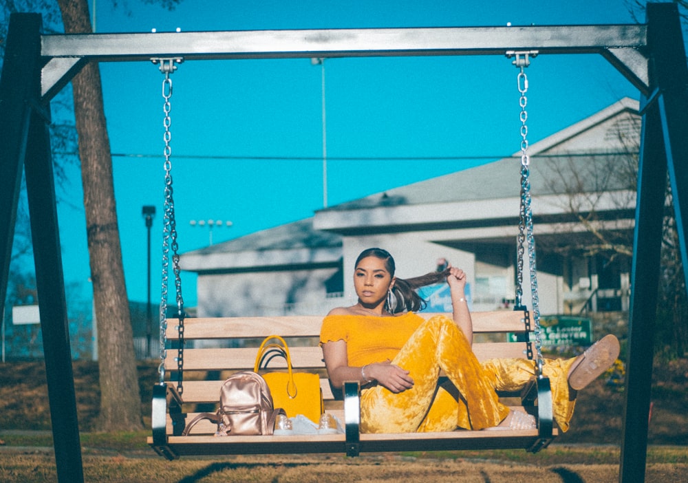 woman in yellow dress sitting on swing chair