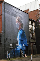 woman in blue dress standing near building during daytime