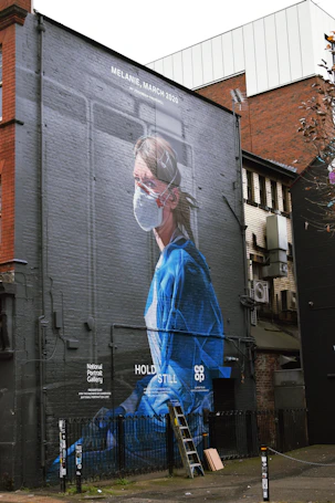woman in blue dress standing near building during daytime