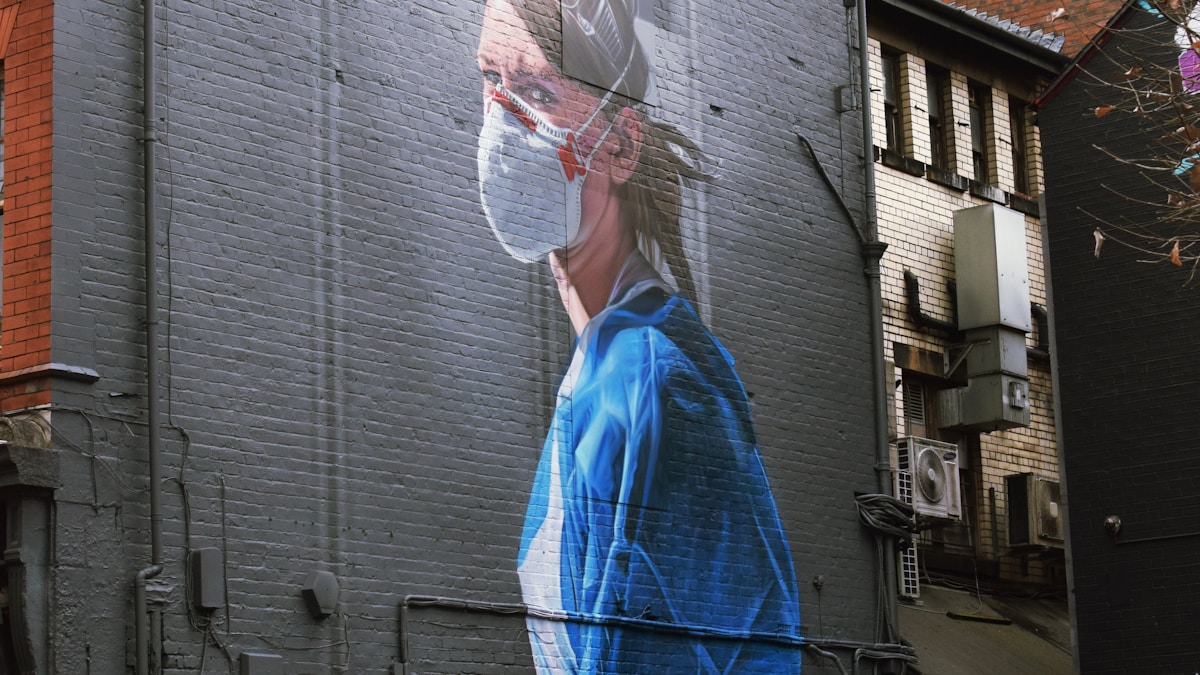 woman in blue dress standing near building during daytime