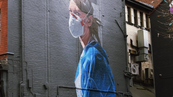 woman in blue dress standing near building during daytime