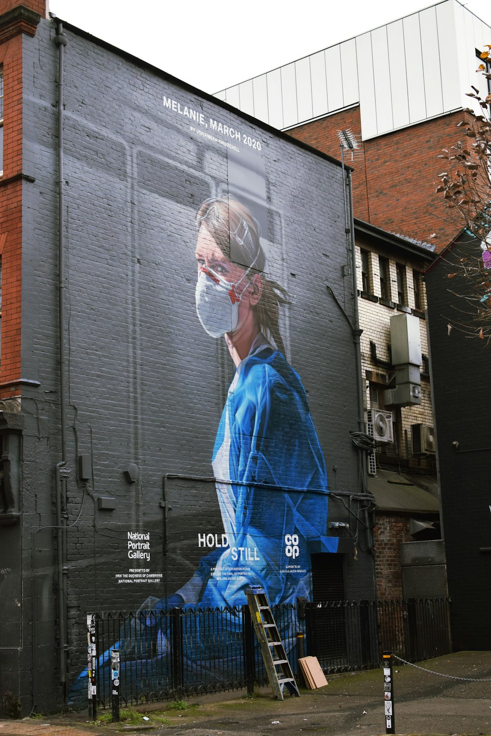 woman in blue dress standing near building during daytime