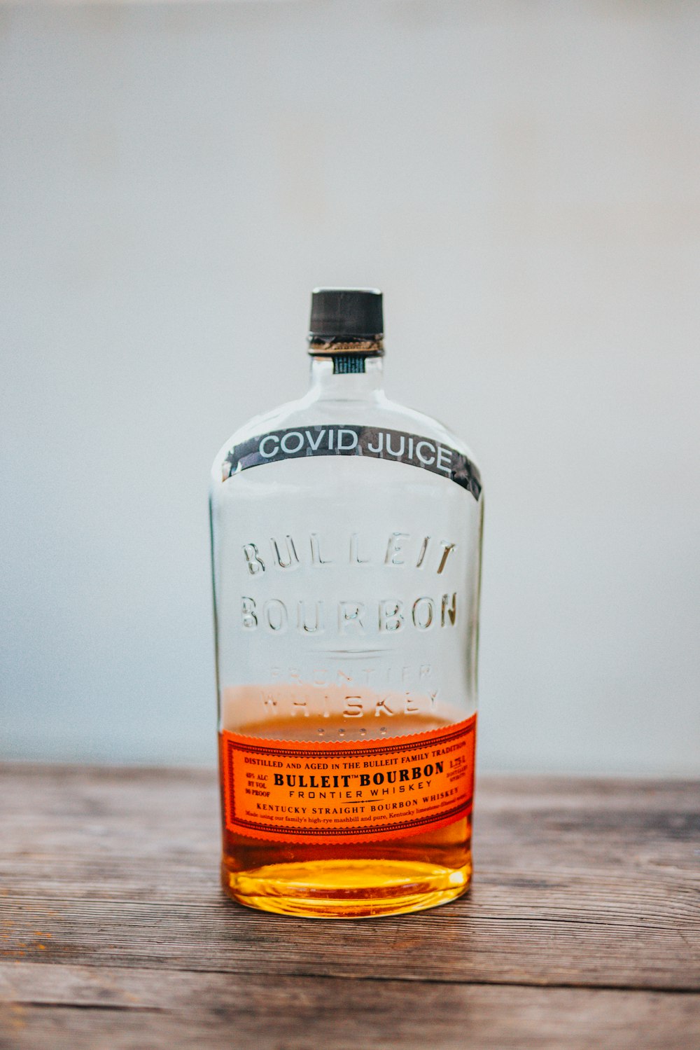 clear glass bottle on brown wooden table