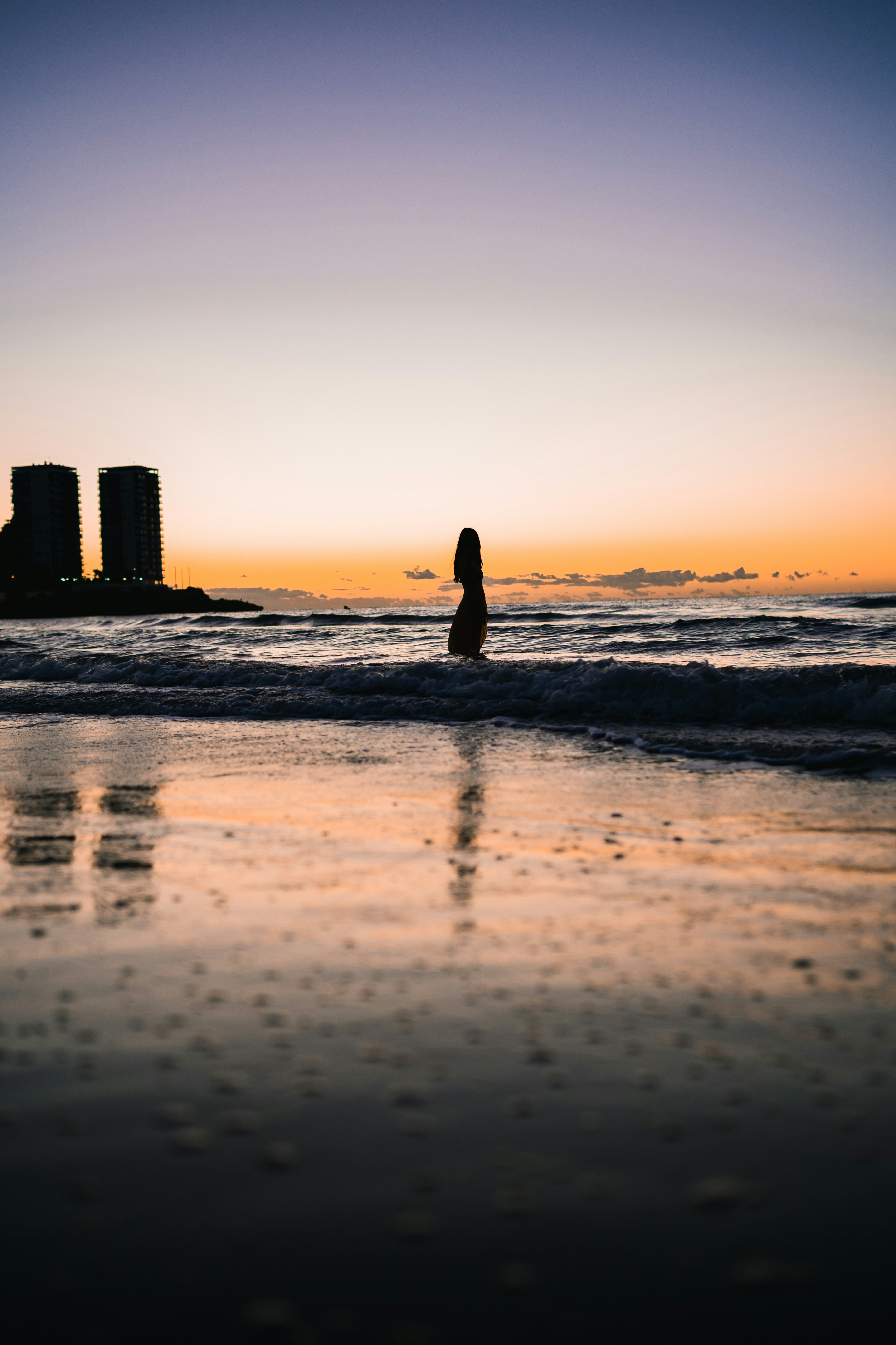 silhouette of woman walking on beach during sunset