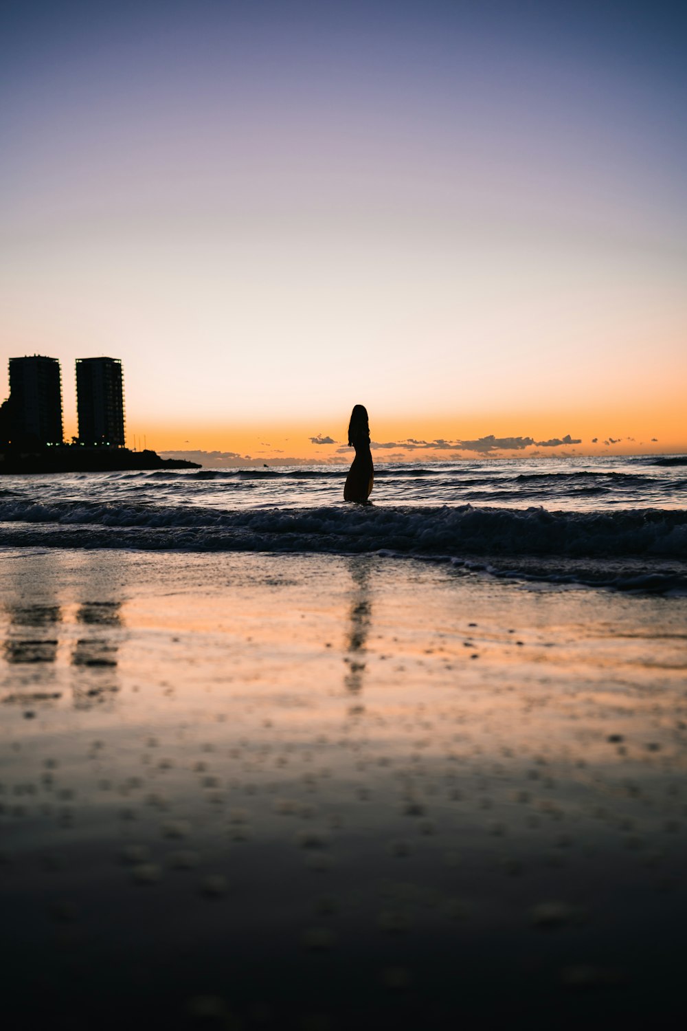 silhouette of woman walking on beach during sunset