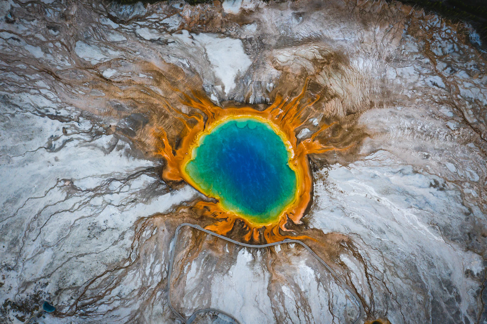 Aerial view of Grand Prismatic Spring in Yellowstone, with rings of blue, green, yellow and orange