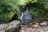 green moss on gray rocks beside river