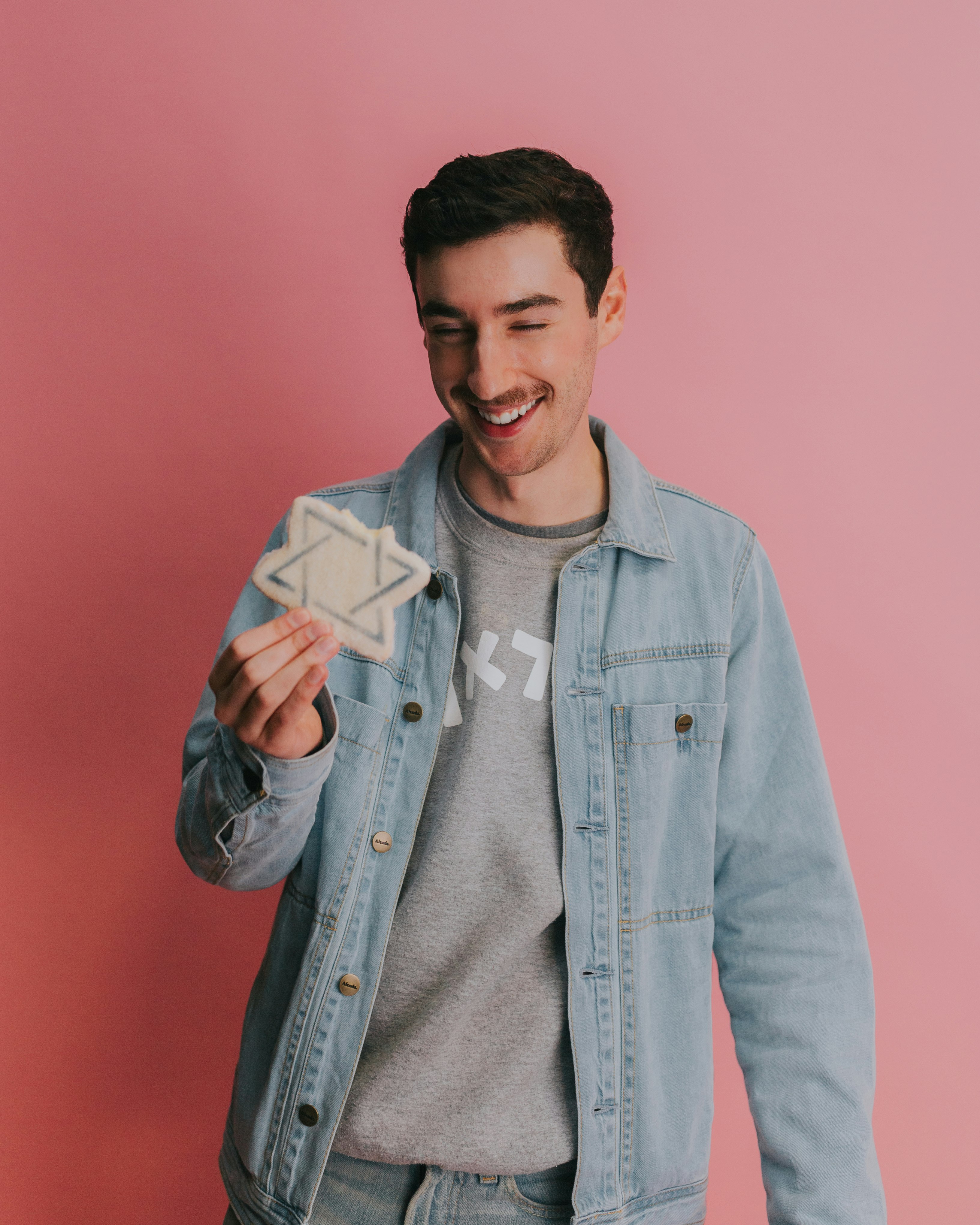 man in blue denim button up jacket holding white card