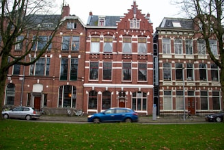blue car parked in front of brown concrete building