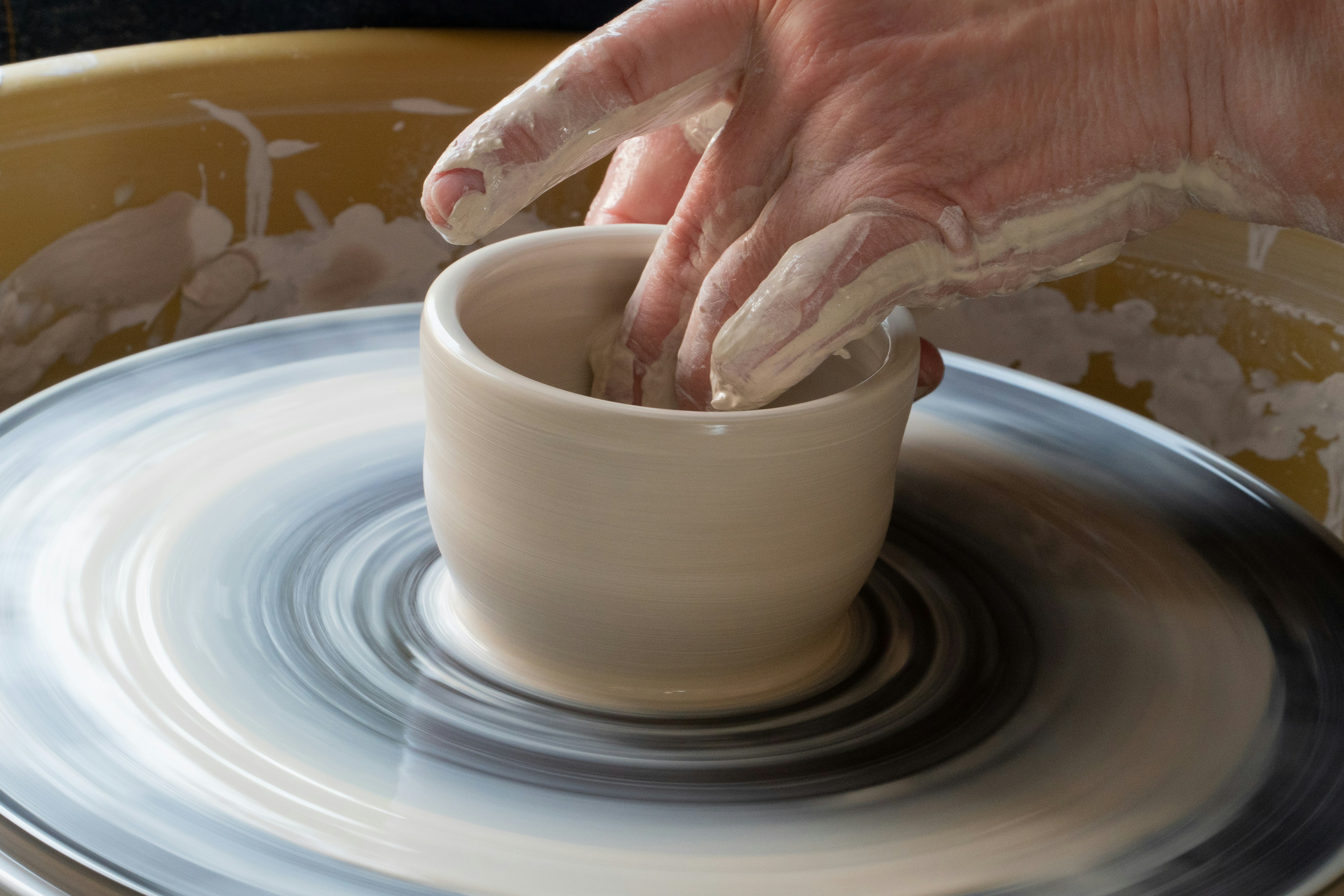 Creating cups on a potter's wheel.