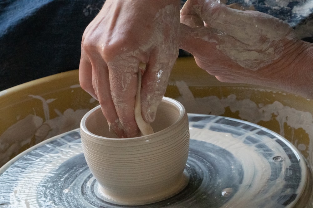 Person, die eine runde Schale aus weißer Keramik hält