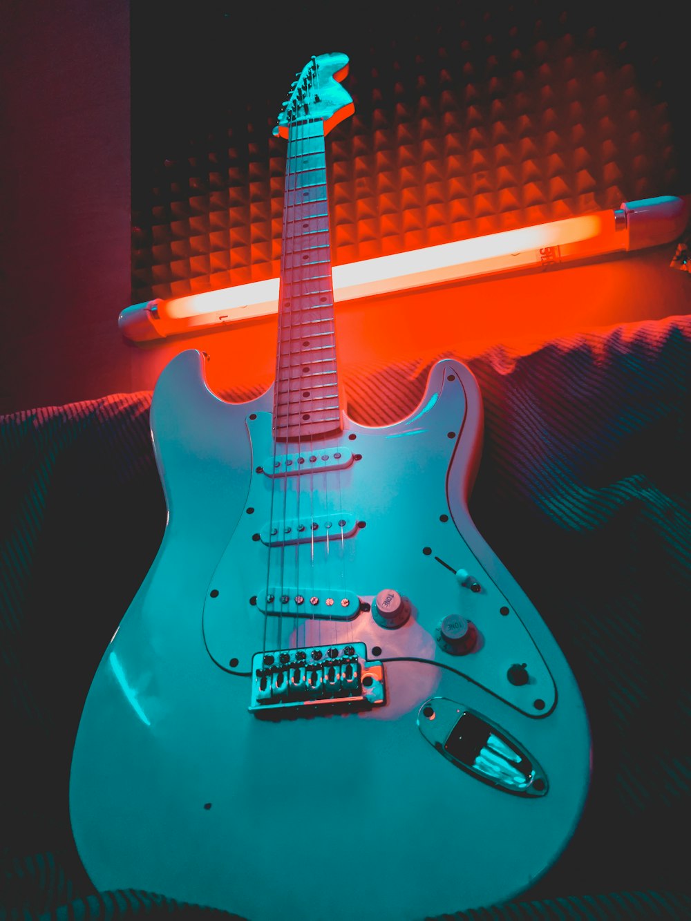 white and brown stratocaster electric guitar