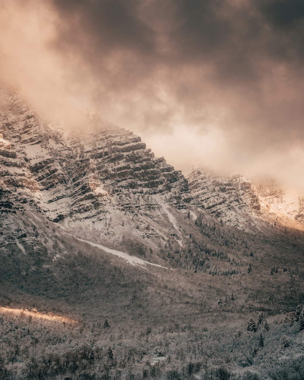 snow covered mountain under cloudy sky