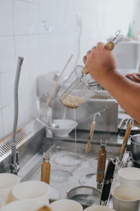 A plumber fixing a kitchen sink with tools in hand.