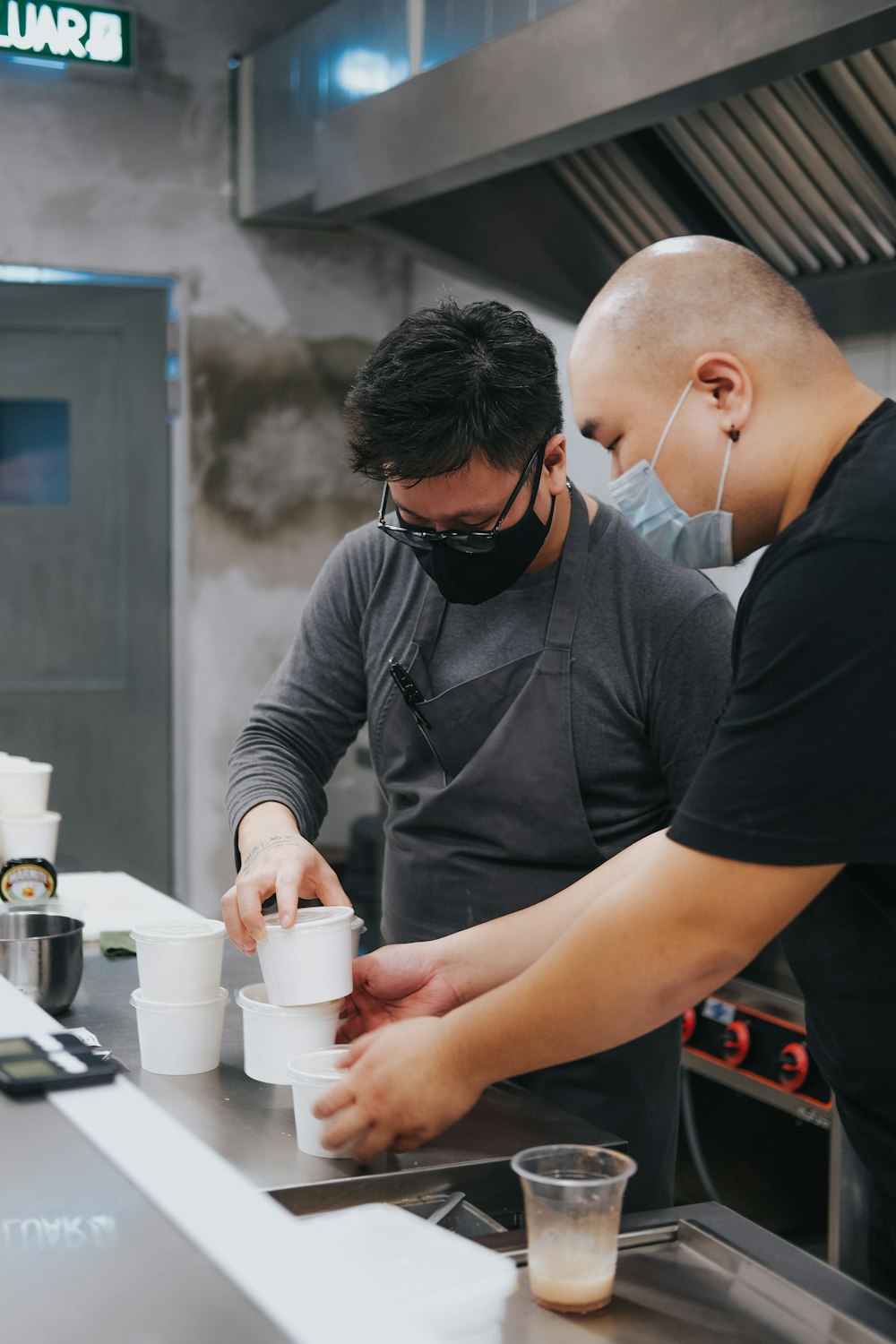 a couple of men in a kitchen preparing food