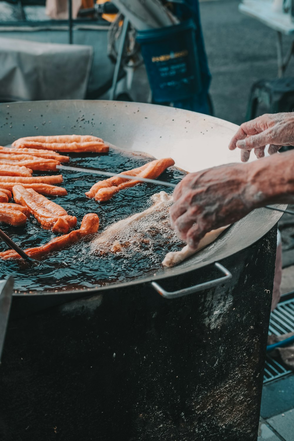 person holding a raw meat on a charcoal grill