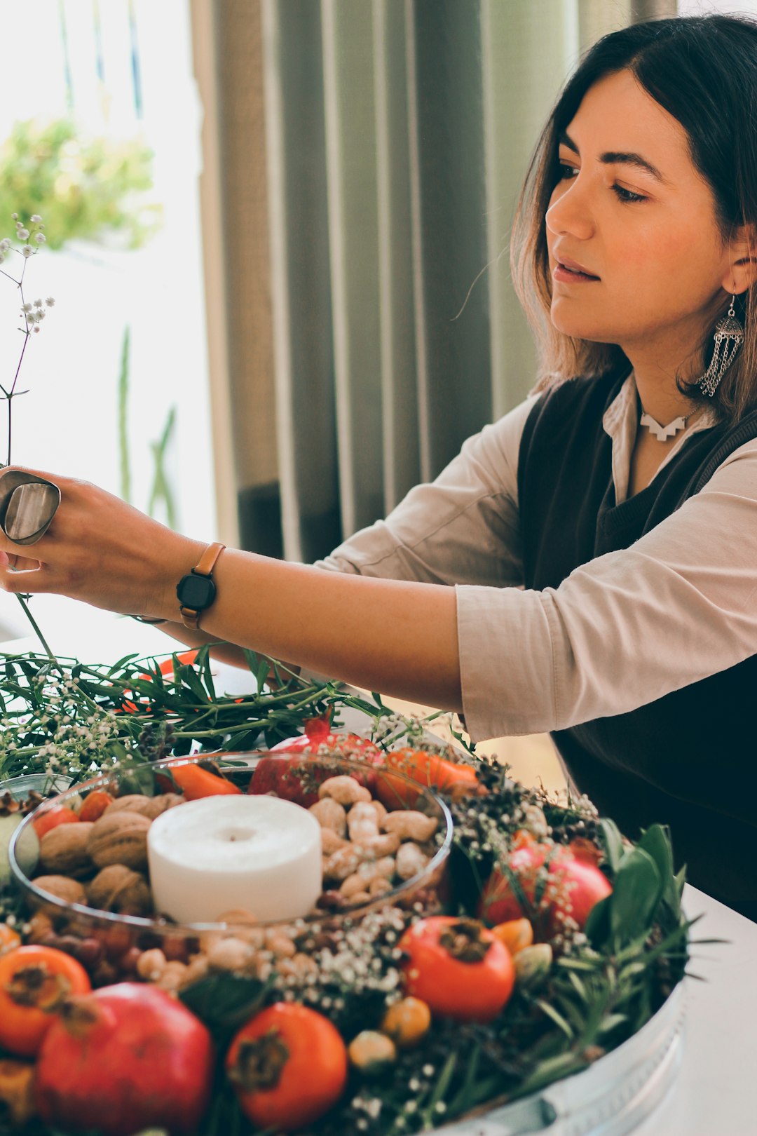 woman in white long sleeve shirt holding green plant