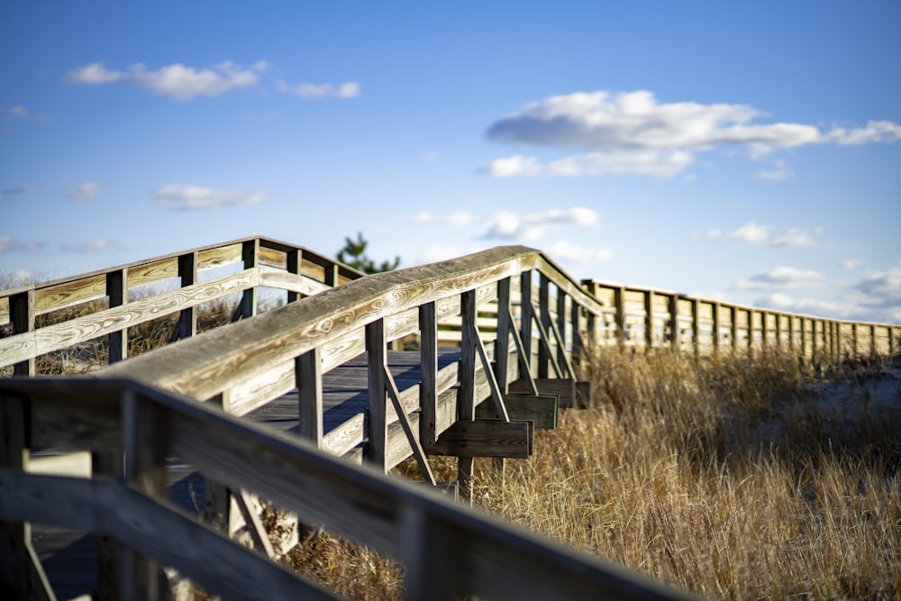 brown wooden fence on brown grass field under blue sky during daytime