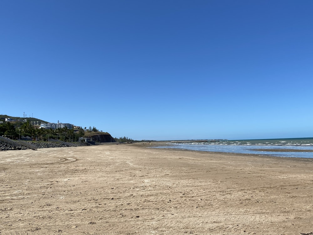 brown sand near body of water during daytime