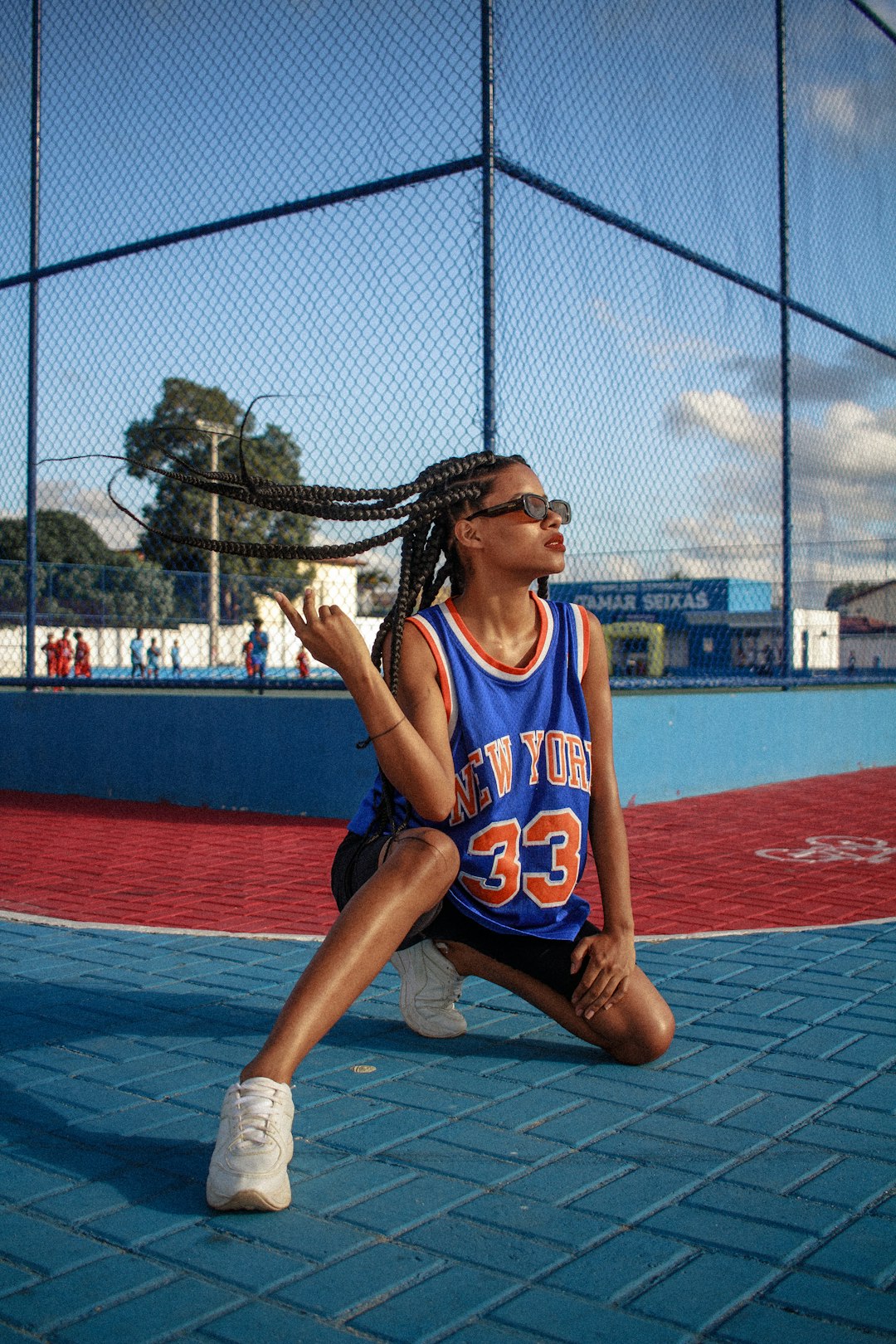 woman in blue and white jersey shirt sitting on basketball court