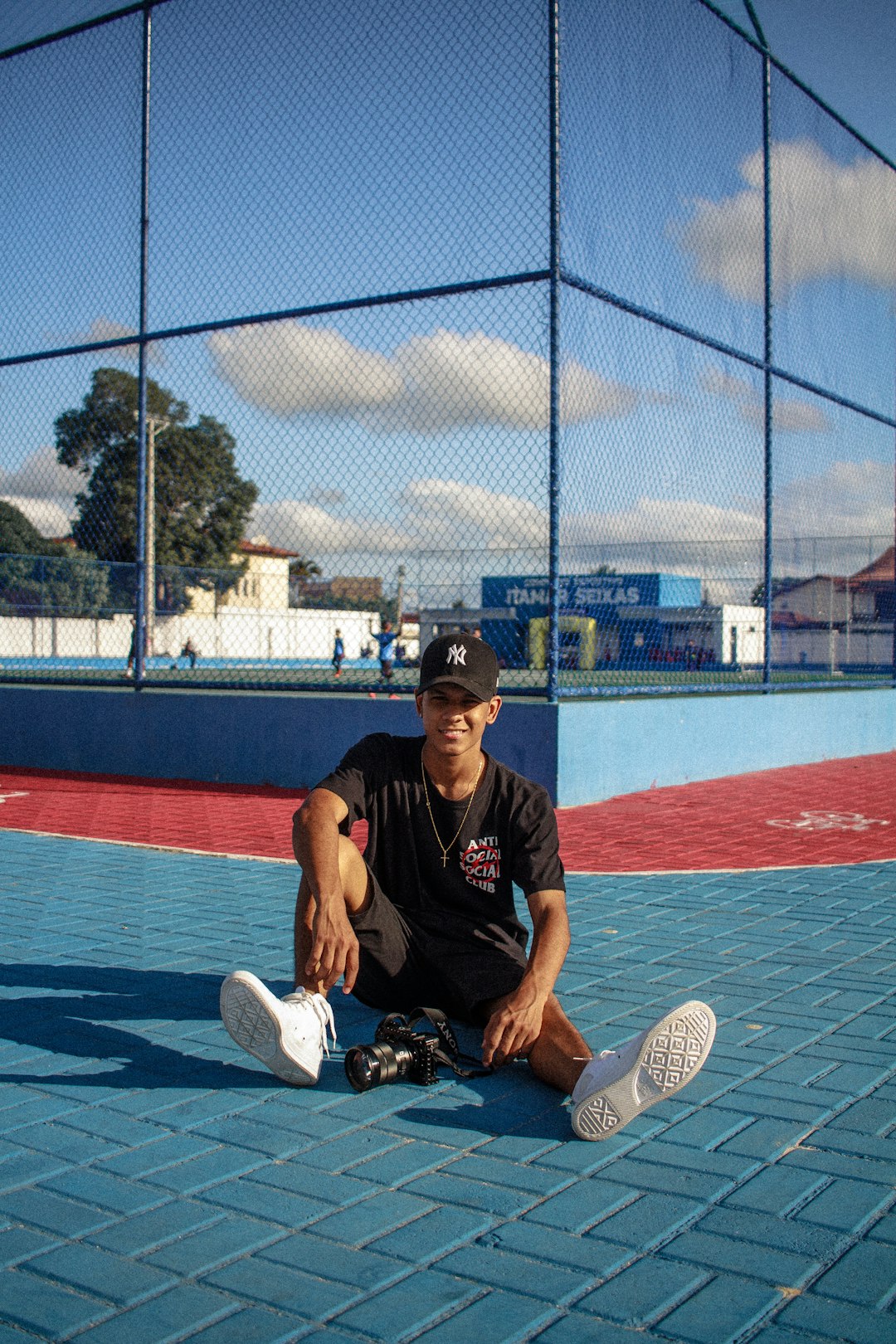 man in black crew neck t-shirt and black pants sitting on tennis court