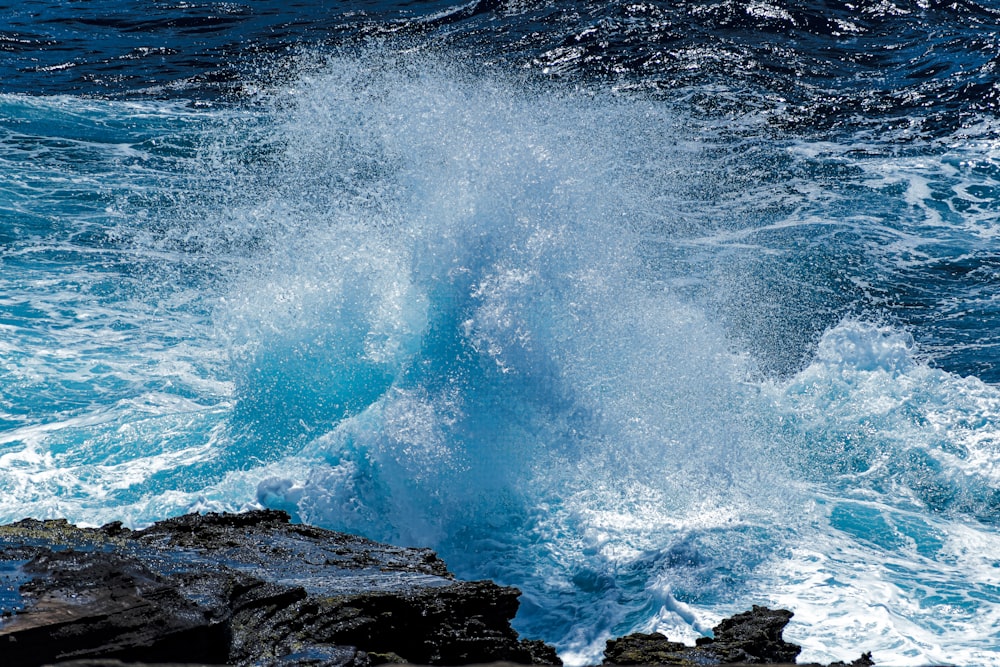 ocean waves crashing on rocky shore during daytime