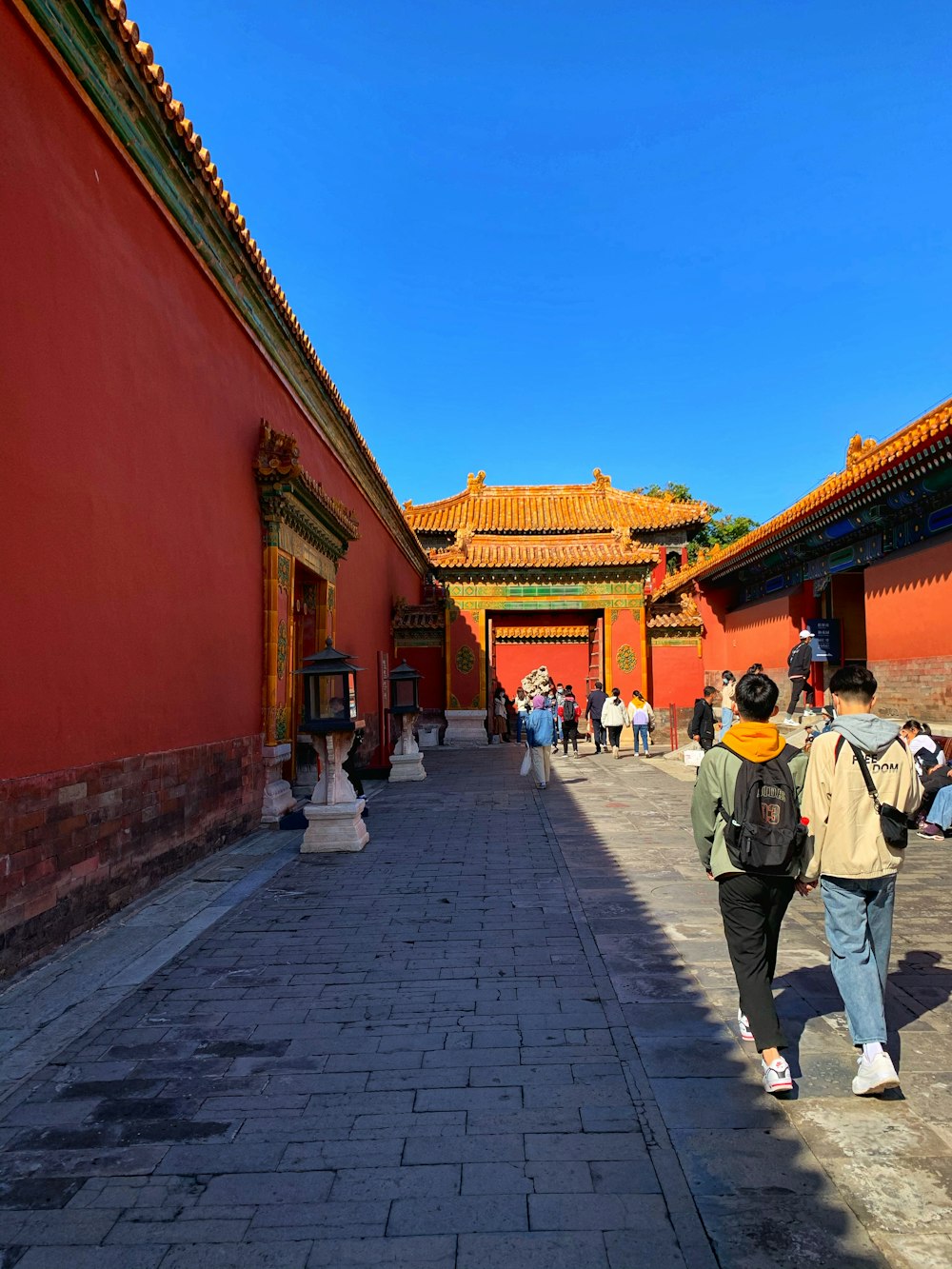 man in white shirt walking on sidewalk during daytime