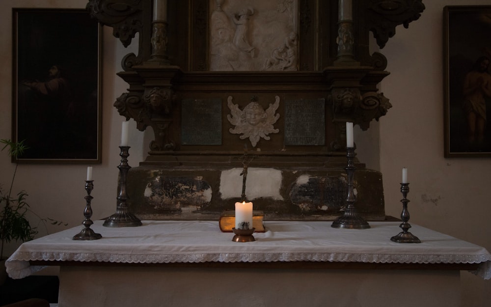 a lit candle on a table in a church