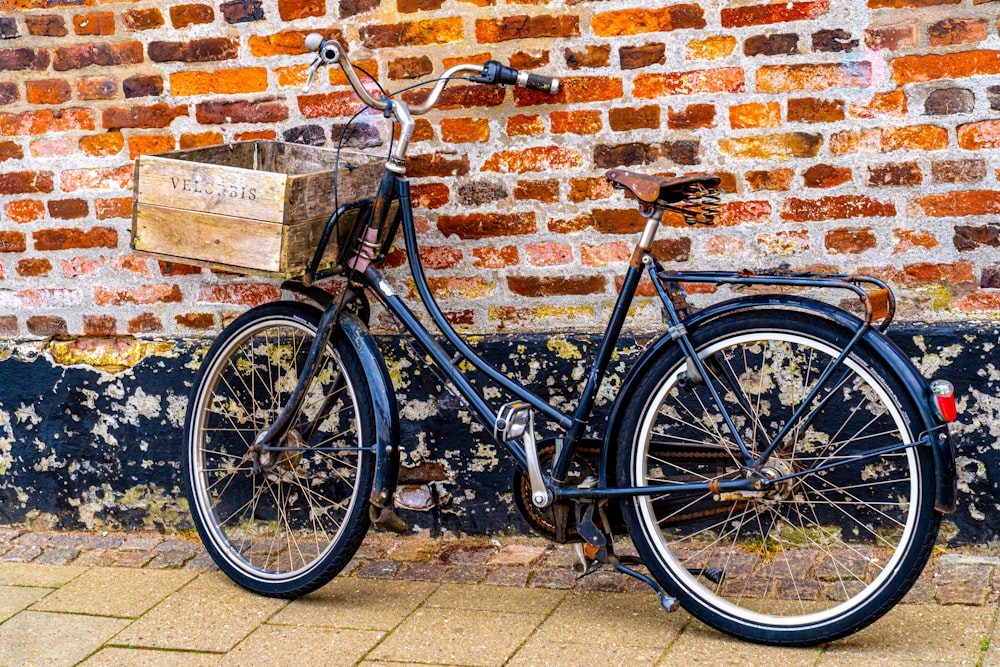 black commuter bike beside brown brick wall