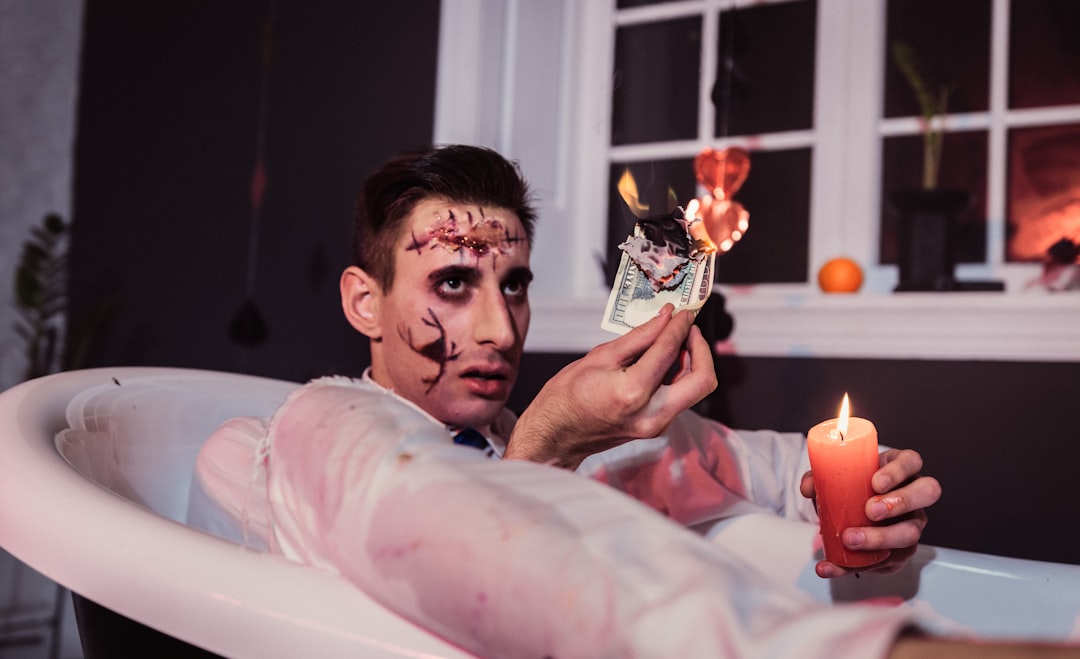 man in white shirt holding lighted candle