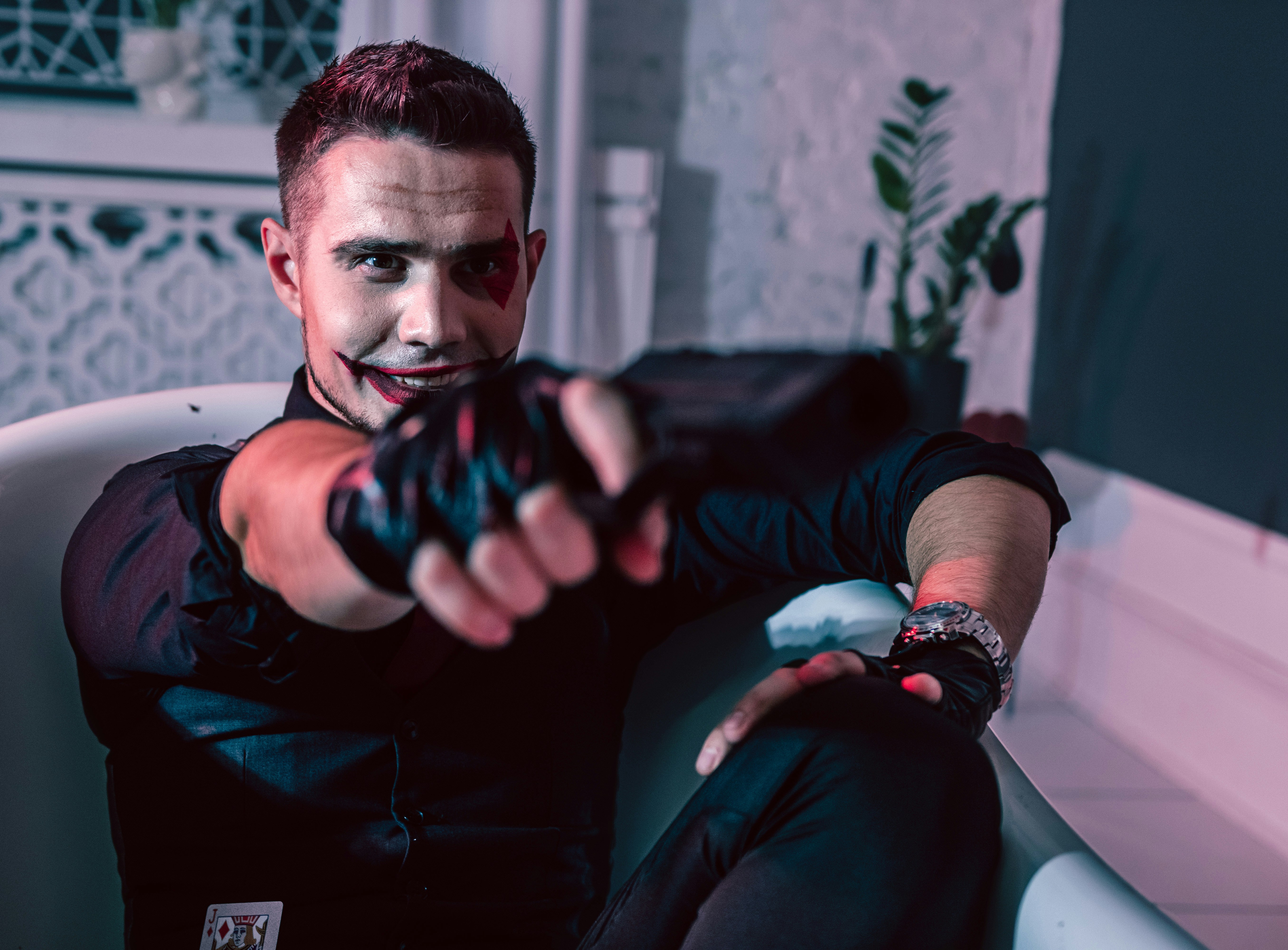 Pria berkaos leher kru hitam duduk di sofa hitam