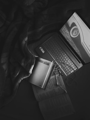 A cozy corner with vintage branded shoes and a handwritten note beside a phone and laptop.